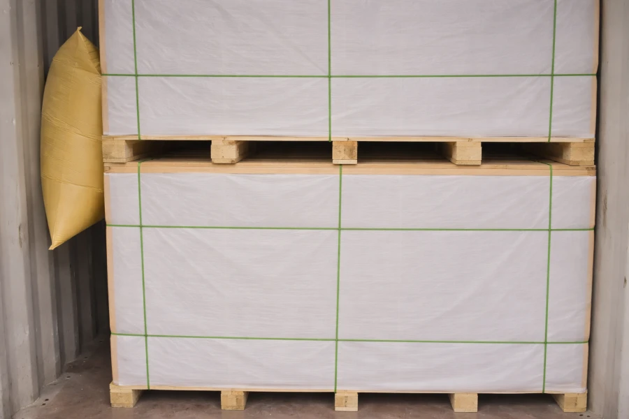 Two stacked pallets loaded with magnesium oxide boards are placed inside the container, with the adjacent gaps filled with airbags to protect the pallets from damage.