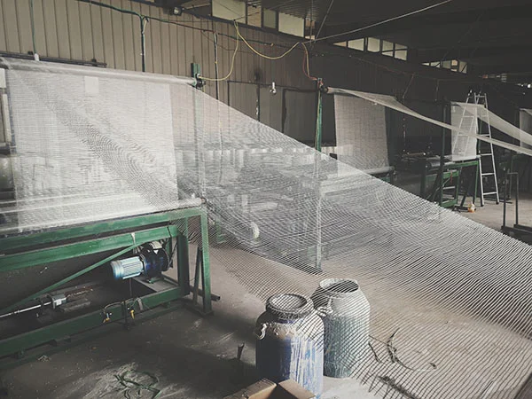 Acrylic coating being applied to fiberglass mesh during production